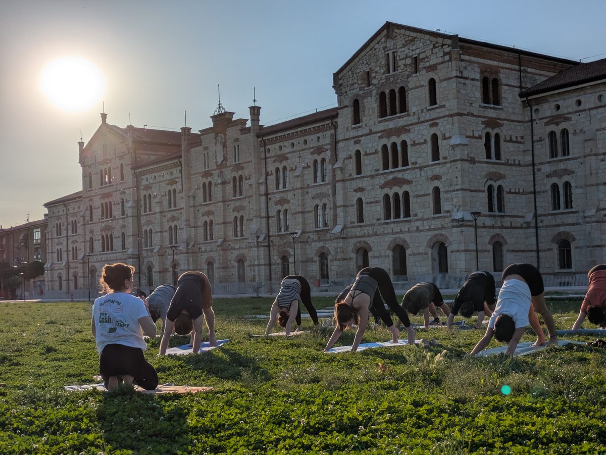 Lezione di yoga all'aperto sul prato davanti alla Provianda di Santa Marta